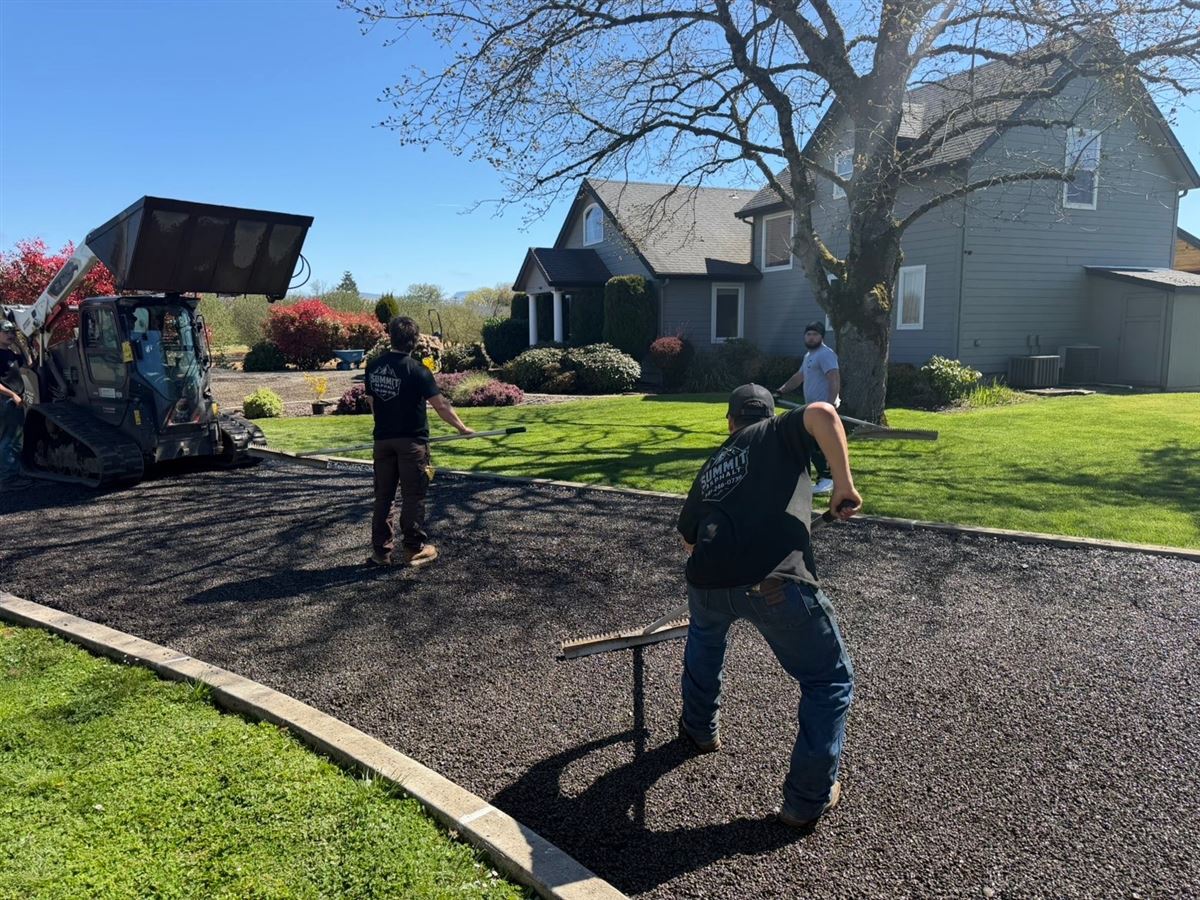 Crew finishing a freshly paved residential driveway